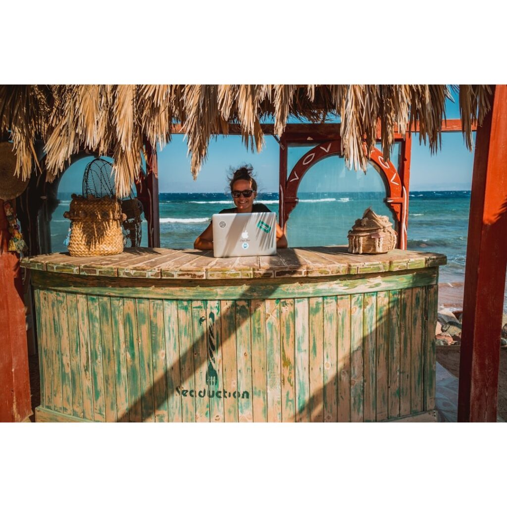 A person doing remote work at the beach.